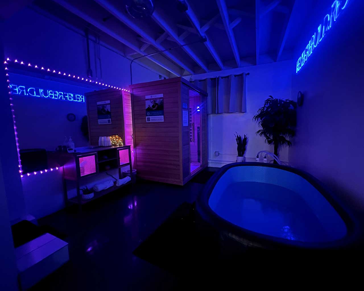 Recovery room at Posture Lab LA featuring a cold plunge tub, infrared sauna, and ambient lighting, emphasizing wellness and recovery therapies.