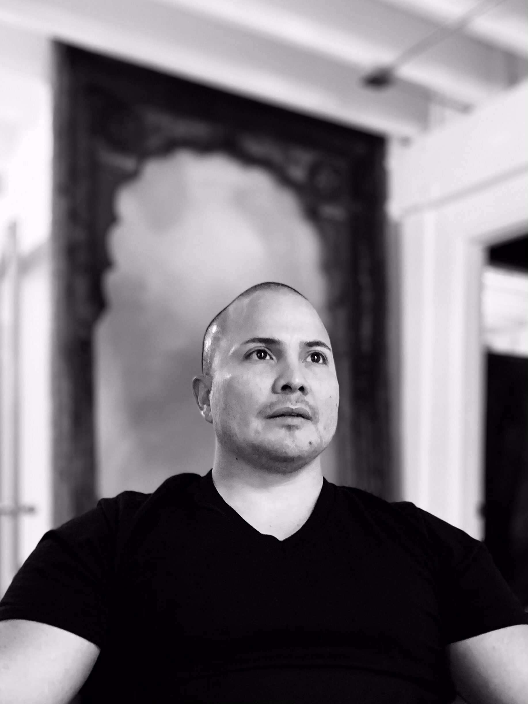 Joseph Gonzalez, holistic health practitioner and founder of The Posture Lab, seated in contemplative pose, with a blurred background reflecting a therapeutic environment.